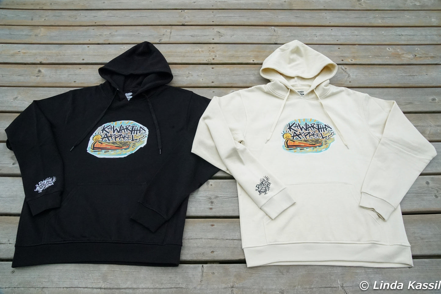 Kawartha Apparels Founders Edition Hoodie in Cottage White and black laid flat on a dock